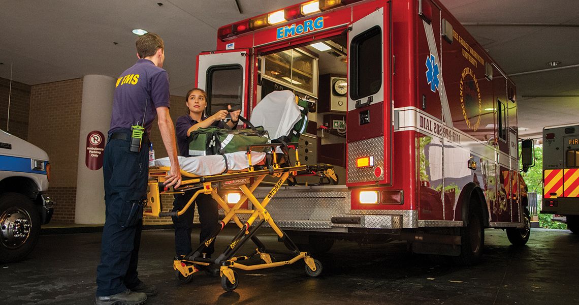 EMTs loading a stretcher into the back of an ambulance