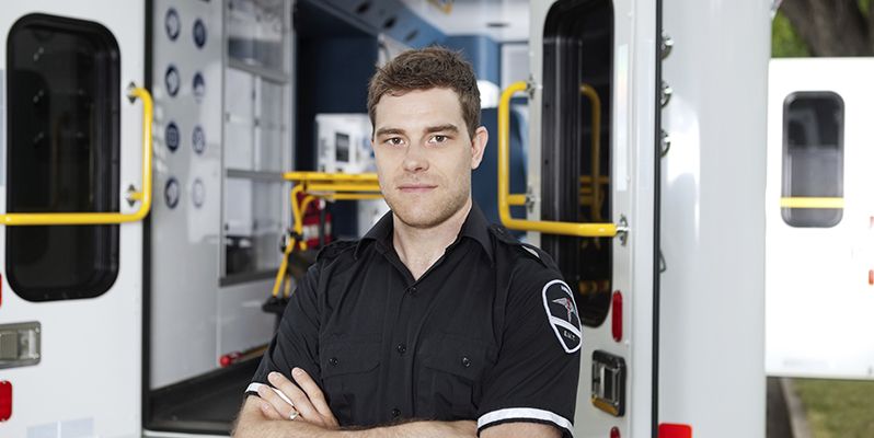 Paramedic standing in front of an ambulance